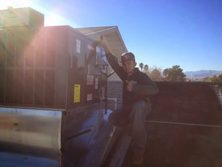 HVAC technician performing AC Tune-Up on a rooftop unit in Middletown