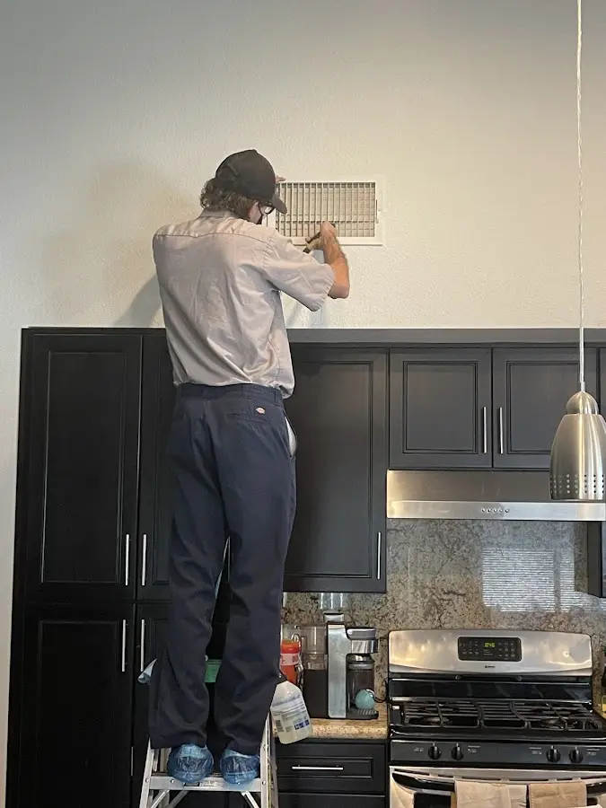 Technician inspecting an air vent during HVAC service in Middletown